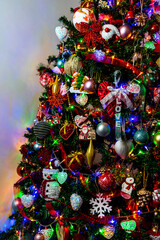 Wall Mural - Vertical closeup shot of a beautifully decorated Christmas tree with illuminated lights