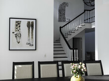 Beautiful View Of A Modern Room With A Long Table, Animal's Pictures, And Stairs