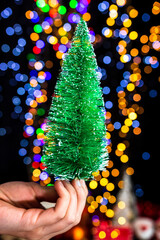 Sticker - Man holding a decoration against bokeh Christmas lights