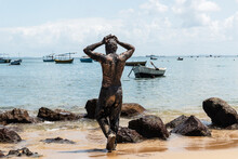 Man Covered In Oil Entering The Sea.
