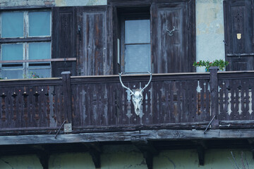 Wall Mural - Old rusty balcony decorated with a scary figurine hanging from it