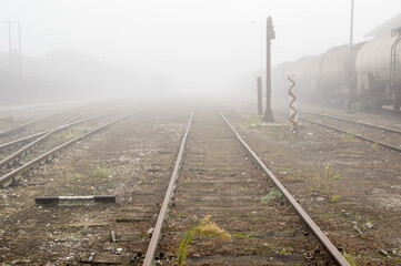 Sticker - Railway track coming out of the fog on an empty station