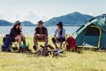 happy friends in camping party having fun together and drinking on holiday summer