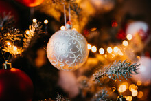 Closeup Shot Of A White Ball With An Elegant Spiral Pattern On An Illuminated Christmas Tree