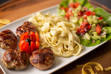 Wall Mural - Closeup shot of delicious pasta served with meatballs and a healthy salad