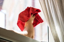 Man Wiping Window Using Red Microfiber Rug - Housekeeping Concept