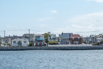 Canvas Print - Scenic view of residential buildings surrounded by the ocean on a clear sky background