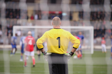 Canvas Print - Goalkeeper seen during the football match through the gates