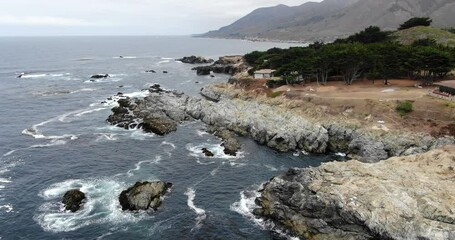 Canvas Print - An aerial view of foam waves hitting the rocky coast of Big Sur in California