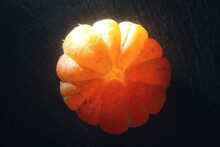 Shiny Mandarin Fruit Creatively Lighted With Sunlight Glow On Dark Background