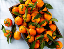 Fresh Mandarin Oranges Fruit Or Tangerines With Leaves In Wooden Box, Top View