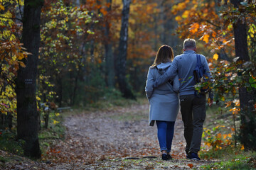 Poster - Mid-age couple walking through the autumn forest