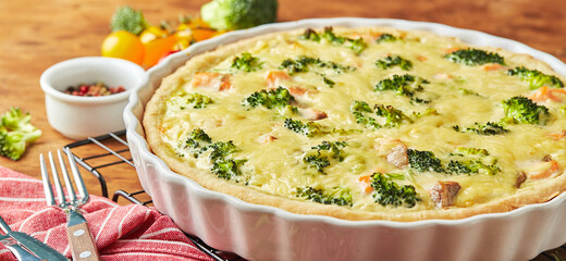 Wall Mural - Homemade quiche with red fish, salmon, broccoli and cheese on wooden background