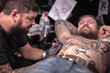 © Mr. Prof - Tattoo specialist making a tattoo in studio