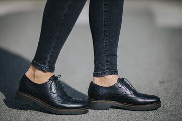 Legs of a female wearing fashionable black loafers