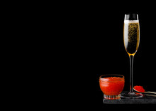Elegant Glass Of Yellow Champagne With Red Caviar On Golden Spoon And Glass Container Of Caviar On Marble Board On Black Background. Space For Text