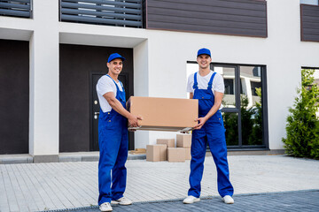 Wall Mural - Two removal company workers unloading boxes from minibus into new home