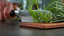 Freeze Motion Of Cutting Chive On Cutting Board.