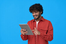 Happy Indian Young Man Using Digital Tablet Isolated On Blue Background. Smiling Ethnic Student Guy Holding Pad Remote Learning In App, Studying Or Communicating, Surfing Online, Reading E Book.