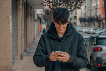 teenage boy on the street with mobile phone