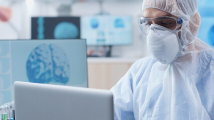 Wall Mural - scientist doctor with ppe equipment typing medical expertise on computer working at medical vaccine 
