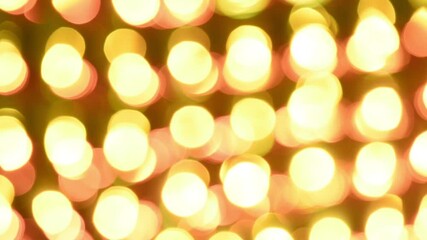 Wall Mural - Glowing and iridescent lights of bokeh. Round golden lights flash, shimmer and move against a dark background. Can be looped.
