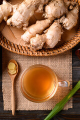 Wall Mural - Ginger tea in cup glass on wooden background, Healthy herbal drink, Table top view