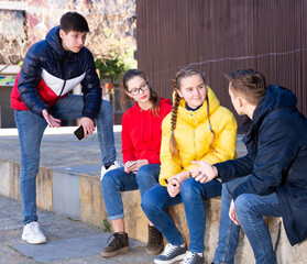  Teenage friends spend time together in city streets in spring. Vacation and teens concept