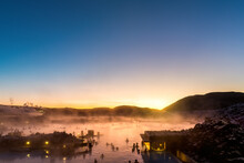 Sunrise Over The Geothermal Pools At Blue Lagoon In Iceland. The Blue Lagoon Is One Of The Most Visited Attractions In Iceland. Unidentified Tourists Enjoy The Warm Waters.