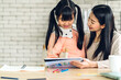 © Art_Photo - Portrait happy love asian family mother teach little daughter asian girl learn and study on table.Mom and asian young girl writing with book and pencil making lessons in homeschool at home.Education