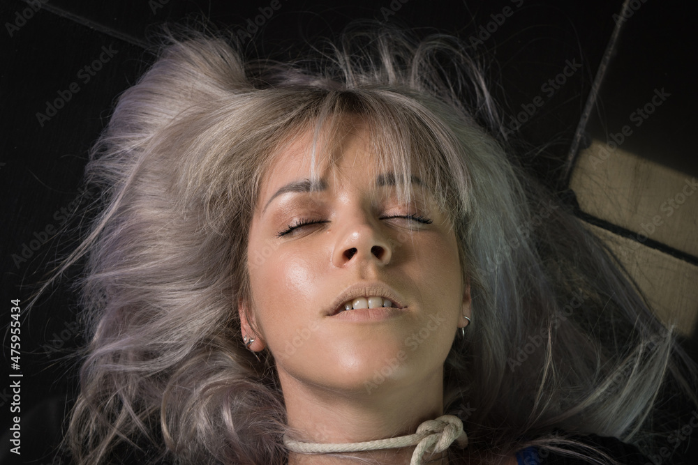 Crime scene simulation: dead girl with hands tied lying on the floor ...