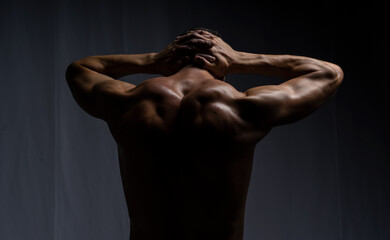 man posing with dumbbells. model in the studio poses, shows muscles, beautiful body relief. spotr, healthy lifestyle