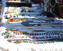 Close Up Of Handmade Colorful Decorated Necklaces And Bead Necklaces With Sunlight On A Table