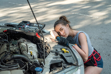 Wall Mural - woman holding work tools standing near broken car and waiting for help