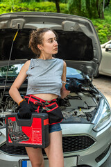 Wall Mural - Young woman hold tools for repair and waiting for help near broken car.