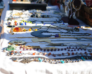 Sticker - Close up of handmade colorful decorated necklaces and bead necklaces with sunlight on a table