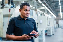Engineer Holding Smart Phone At Automated Factory