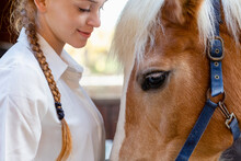 Redhead Woman Looking At Horse In Stable