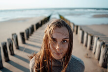Young Woman Near Wooden Posts At Beach