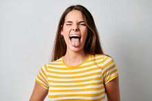 Cheerful Woman Sticking Out Tongue Winking On Gray Background