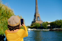 Woman Photographing Eiffel Tower Through Smart Phone, Paris, France