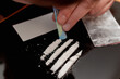 Drug addict. Drug abuse, man taking drugs, snorting lines of cocaine white powder, closeup.