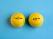 Lemons in shape of woman breast with nipple piercing on blue background.