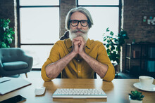 Photo Of Thoughtful Mature Guy Dressed Yellow Shirt Spectacles Looking Modern Gadget Indoors Workshop Workstation