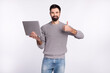 © Tetiana - Photo of young handsome guy use laptop show finger thumb-up advertise approve quality chief isolated over grey color background