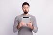 © Tetiana - Photo of young man astonished fake information use tablet modern gadget isolated over grey color background