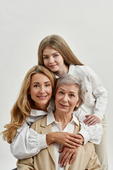 Wall Mural - Pleased three female generations hug each other