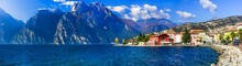 Beautiful Lake  Lago Di Grada. Panoramic View Of Torbole Village With Colorful Houses Amd High Mountains . Italy, Trento