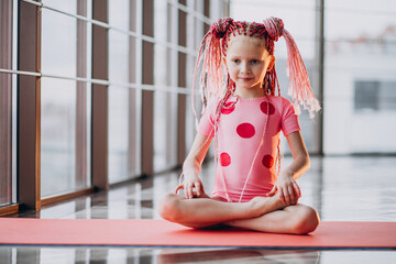 Wall Mural - Cute little girl doing gymnastics on mat in studio