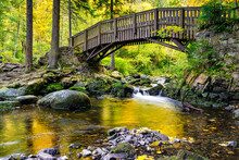 Wooden Bridge Over The Oker River With Large Stones On Engagement Island In The Harz Mountains,